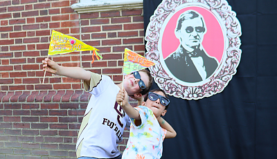 two children hold library pennants at the 150th party banner