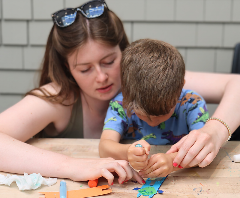 an adult and child work together on a craft project background image