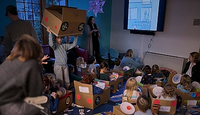 children watching a drive-in movie in repurposed cardboard cards banner