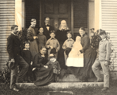 Photograph of Ralph Waldo and Lidian Emerson with children and grandchildren, on the steps of Bush, 1879.
